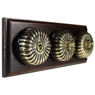 3 Gang 2 Way Antique Brass Fluted Dome With Black Pattress On Horizontal Dark Oak Base