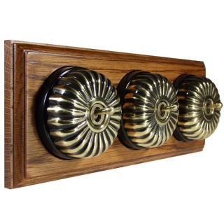 3 Gang 2 Way Antique Brass Fluted Dome With Black Pattress On Horizontal Med Oak Base
