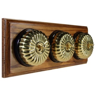 3 gang 2 Way Polished Brass Fluted Dome with Black Pattress Horizontal Med Oak Base